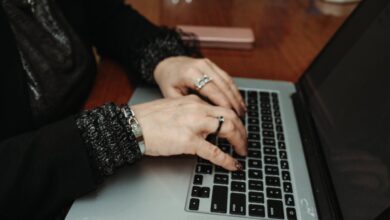 Hands typing on a laptop at a wooden table — an illustrative image of blogging and online writing.