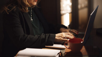 A businesswoman typing on a laptop at her home office desk